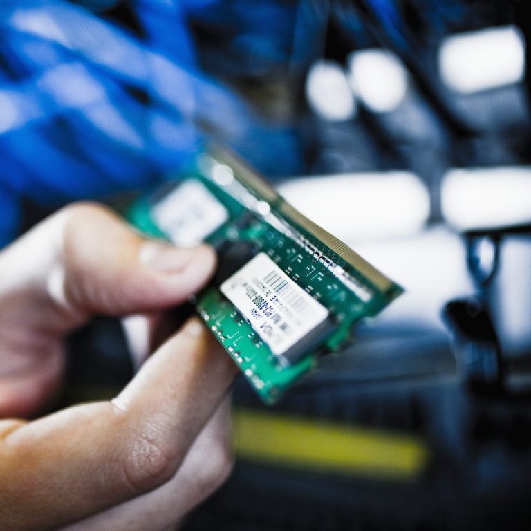 Close-up of computer memory modules with gold connectors and black circuit board.